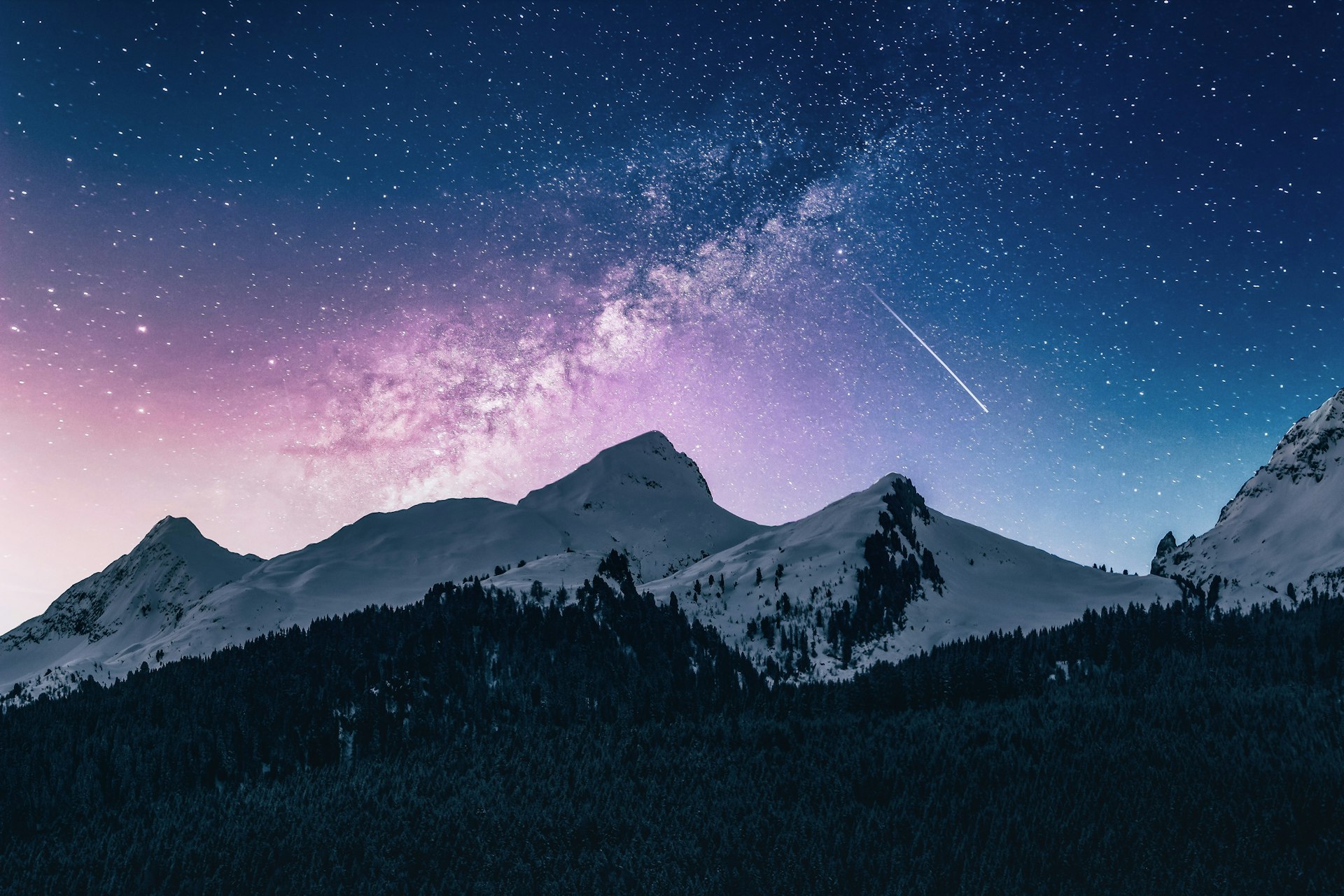 Snow-capped mountains under the Milky Way